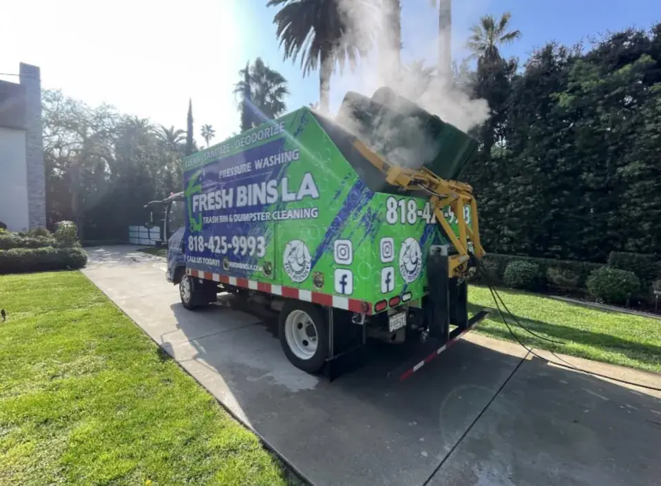 Fresh Bins LA truck steam-cleaning a trash cart in a driveway
